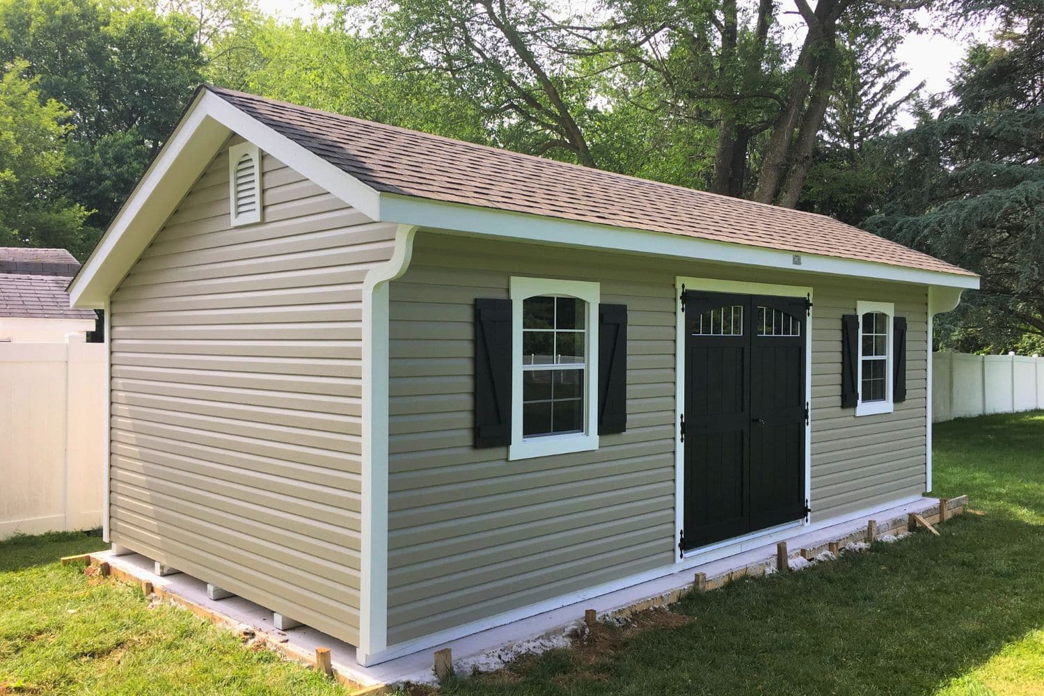 12x24 Vinyl Designer Carriage Shed 1 12x14 Vinyl Designer Carriage Shed on a concrete pad in backyard