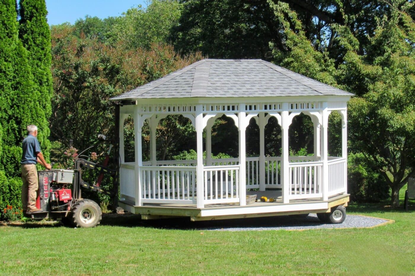 12x16 Vinyl Oval Gazebo set into place by man on equipment