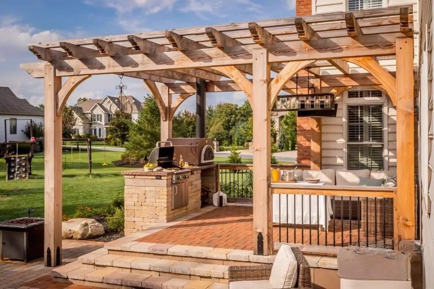 Side view of 13x18 Boulder Pergola in backyard over outdoor kitchen and seating area