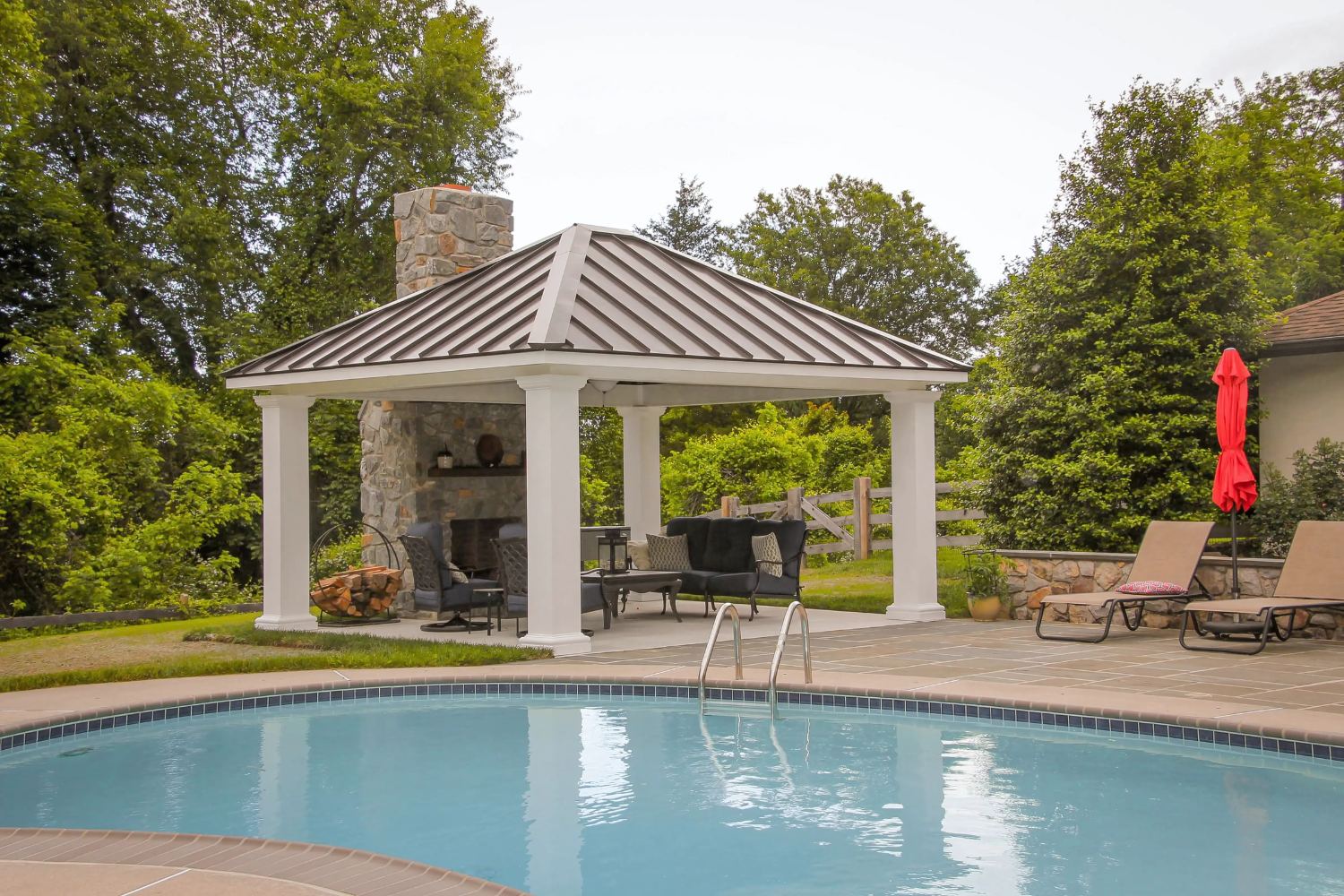 Caribbean Vinyl Pavilion poolside with seating area and fireplace attached