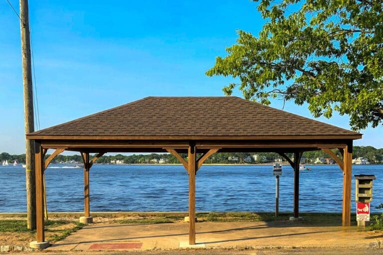Lakefront wood pavilion besides lake and parking lot