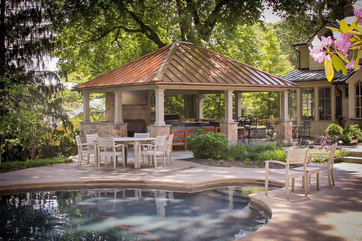 Caribbean Vinyl Pavilion with metal roof besides pool with outdoor kitchen and seating underneath