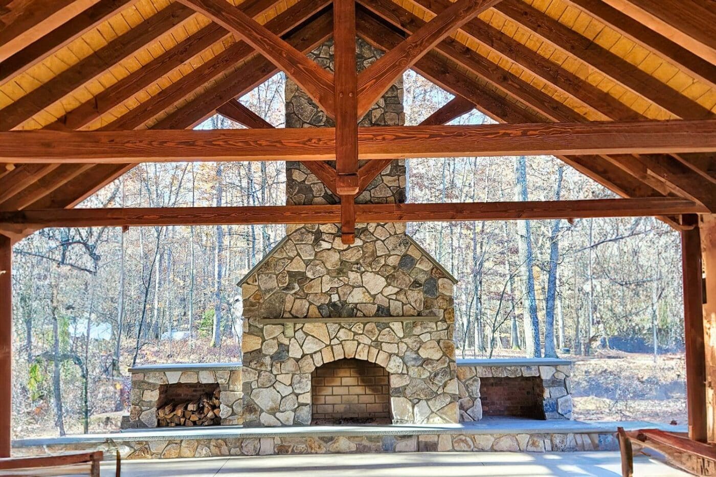view of inside of 30x50 Kingston Pro pavilion with view of expansive stone fireplace and rafters