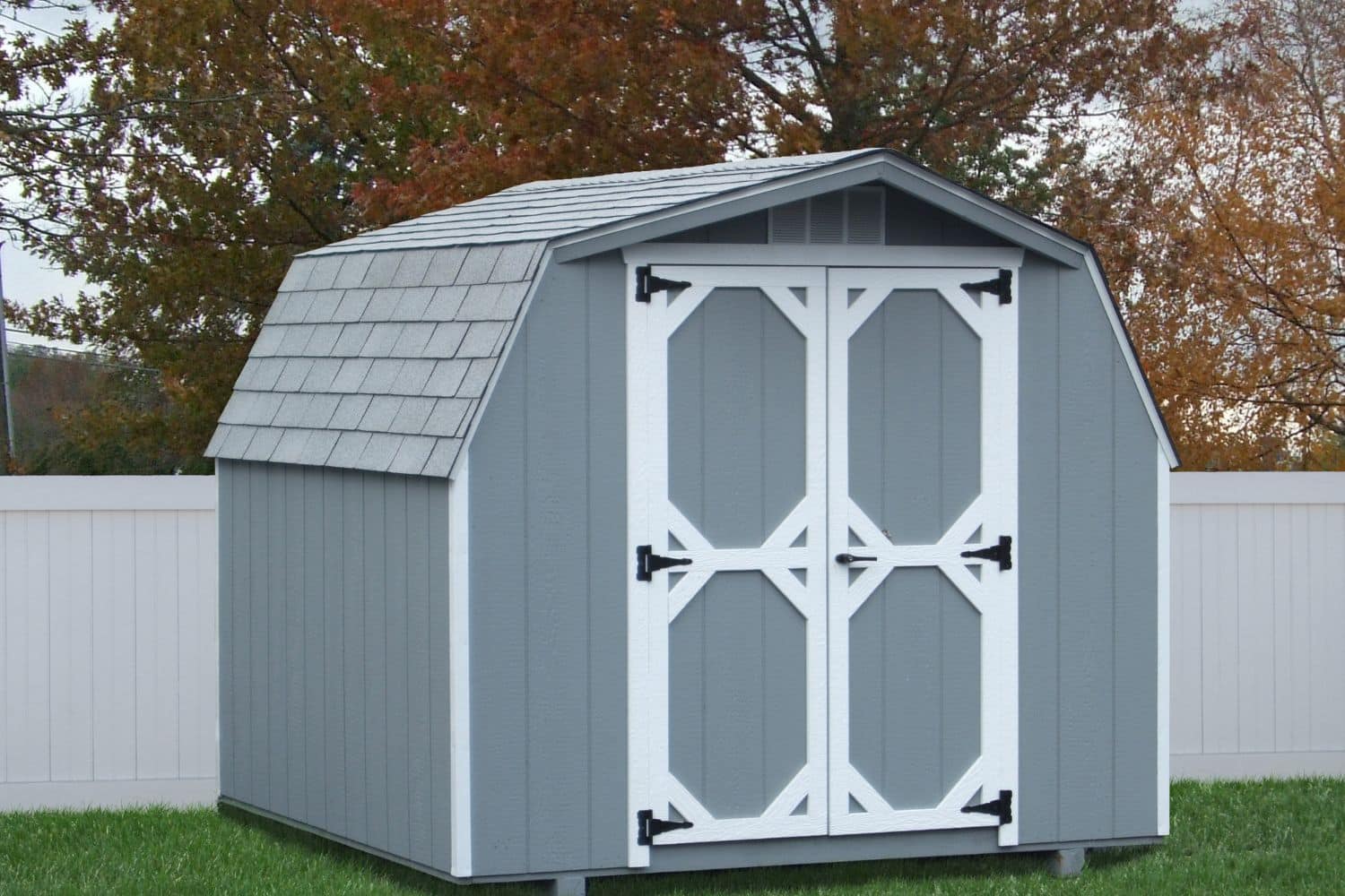 8x10 Wood Mini Barn 1 Blue and White Mini Barn with wood exterior in backyard against fence