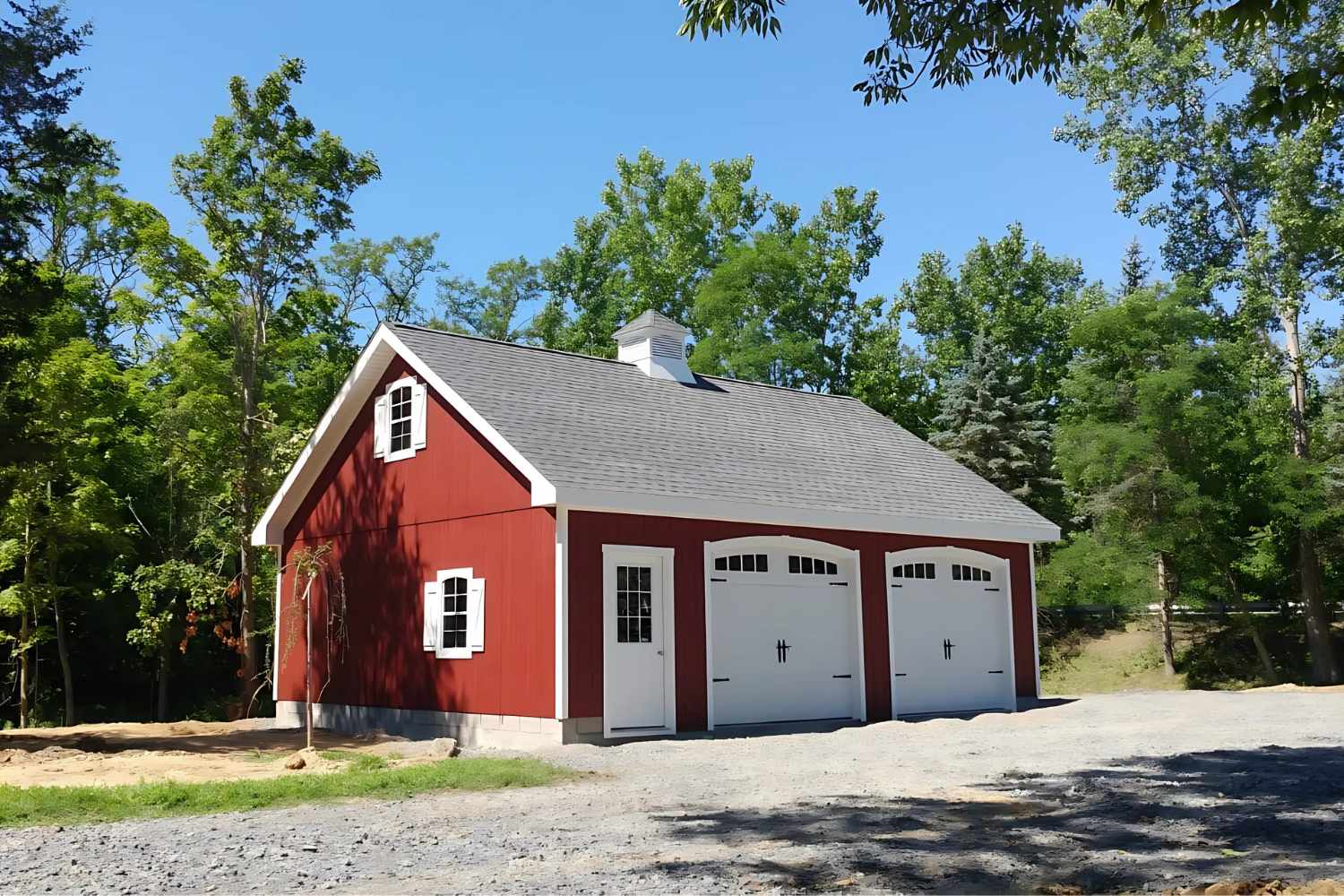 Red A-Frame attic garage at distance with white doors, trim, and cupola