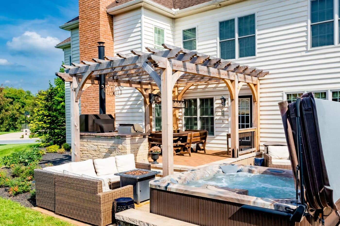 View of Boulder pergola besides hot tub and over grill
