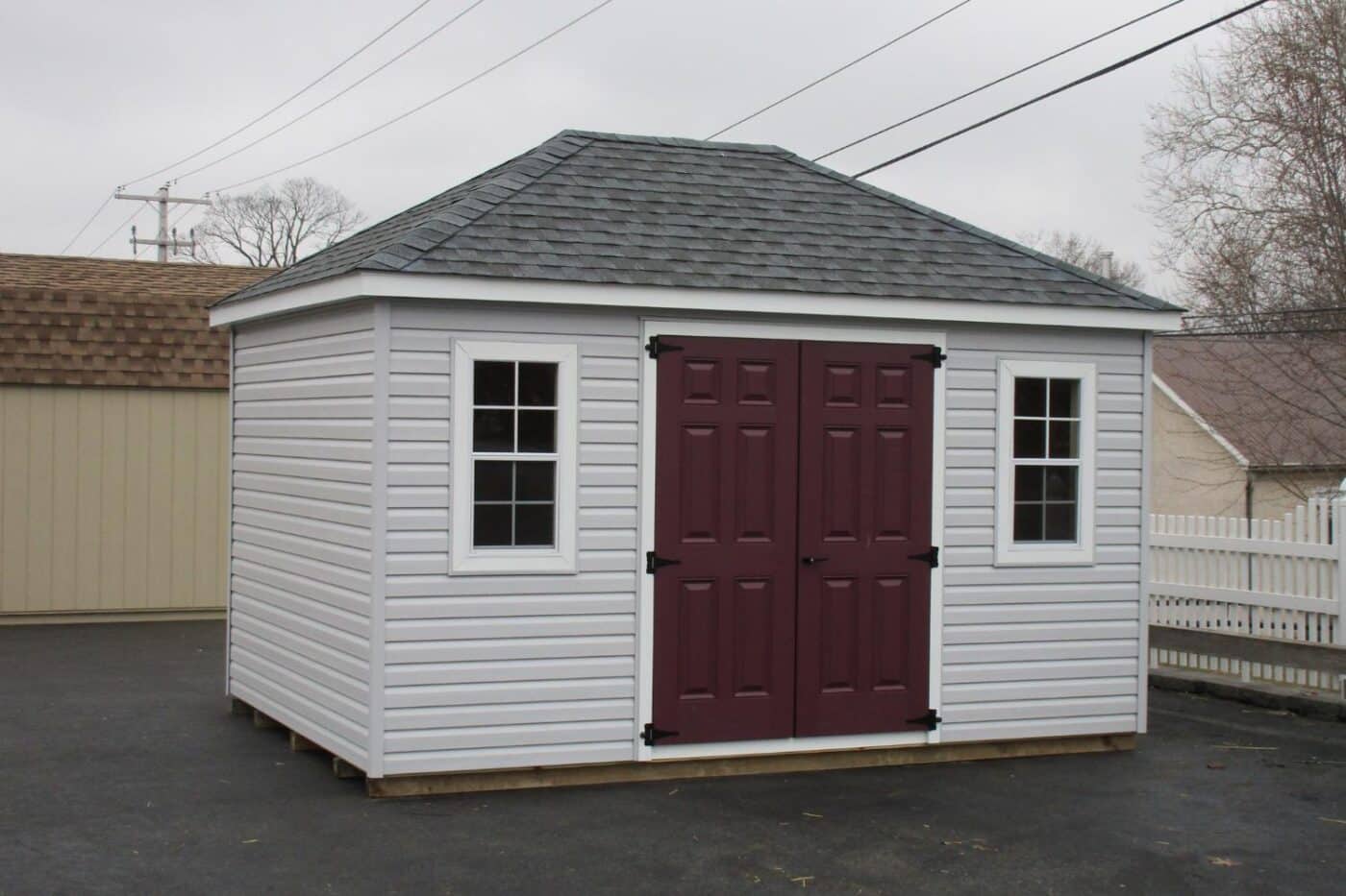 The Cabana Shed 3 White vinyl exterior on Sabana shed with red doors and gray roof