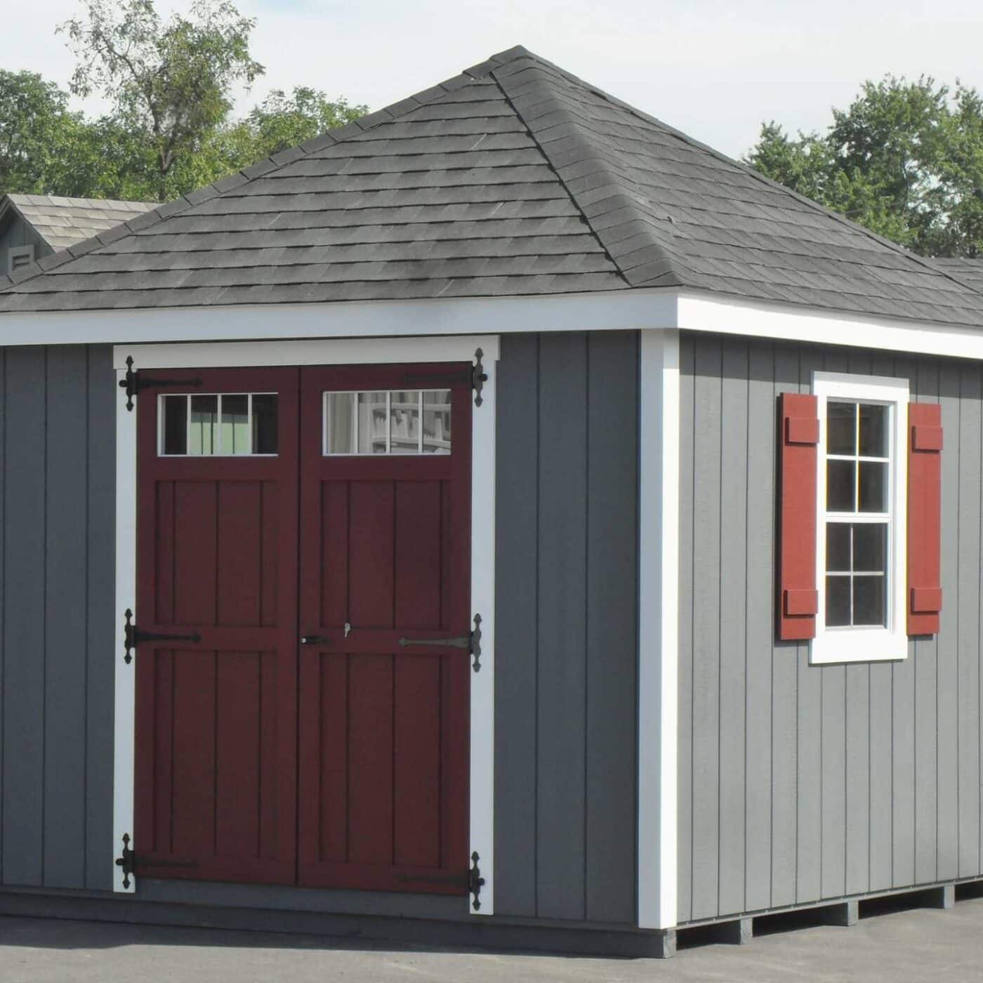 The Cabana Shed 4 Gray and red cabana shed with white trim on concrete lot
