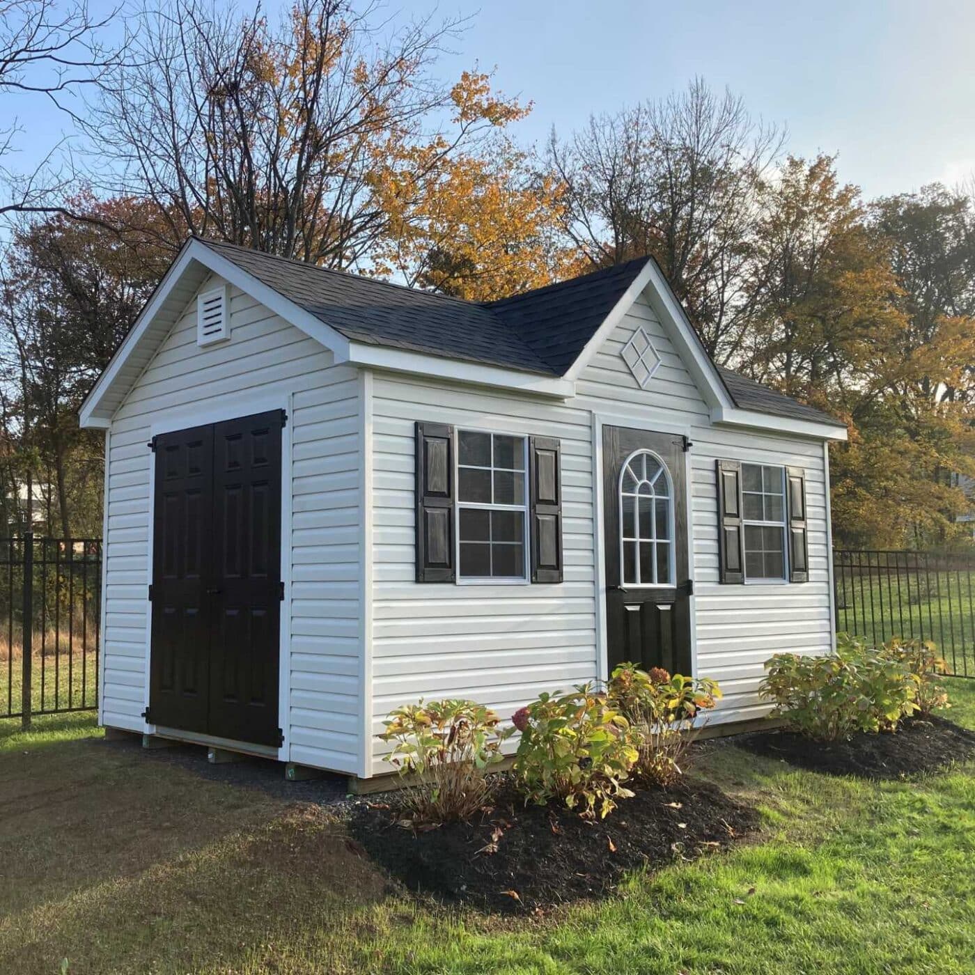 The Cape Cod Shed 4 Cape Cod in garden with black doors and shutters