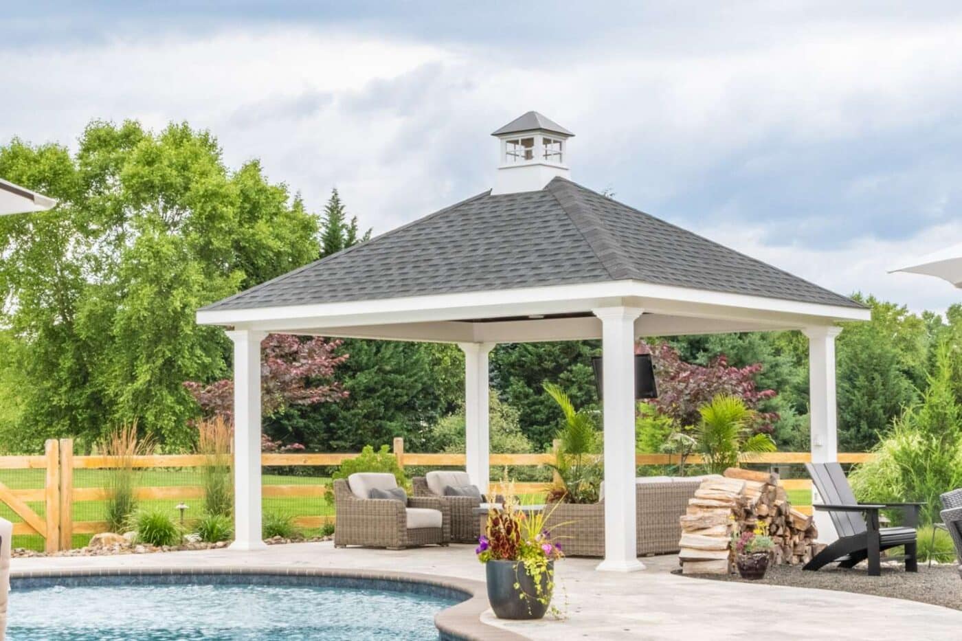 Caribbean Vinyl Outdoor Living pavilion over seating area and besides pool. Pavilion has added cupola