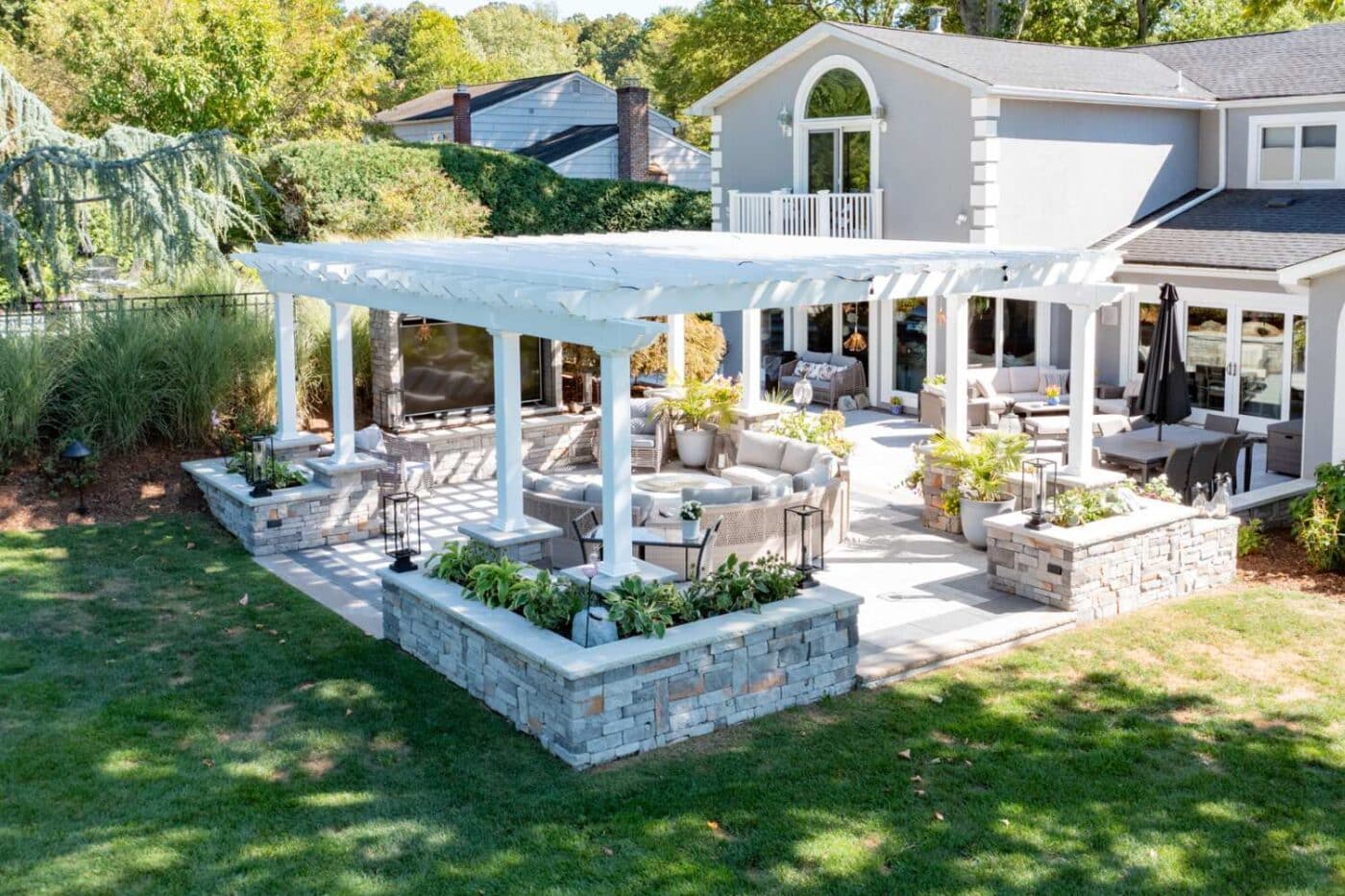 View of carolina vinyl pergola from above with garden and seating underneath