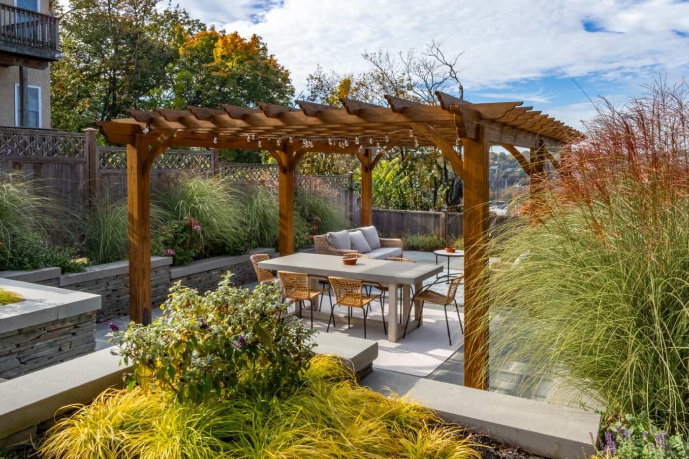 View of wooden Cherokee pergola in garden with seating area underneath