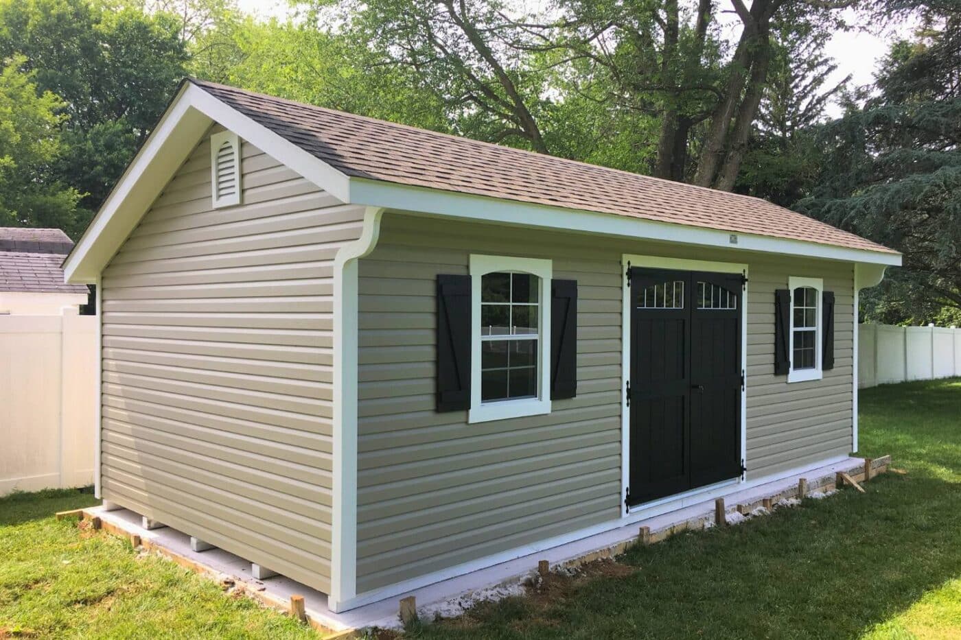 Vinyl Designer Carriage  Shed on concrete pad in backyard 