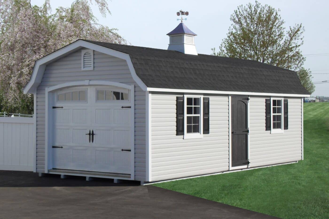 Designer High Barn Garage in white and gray vinyl with cupola and weathervane on grassy field