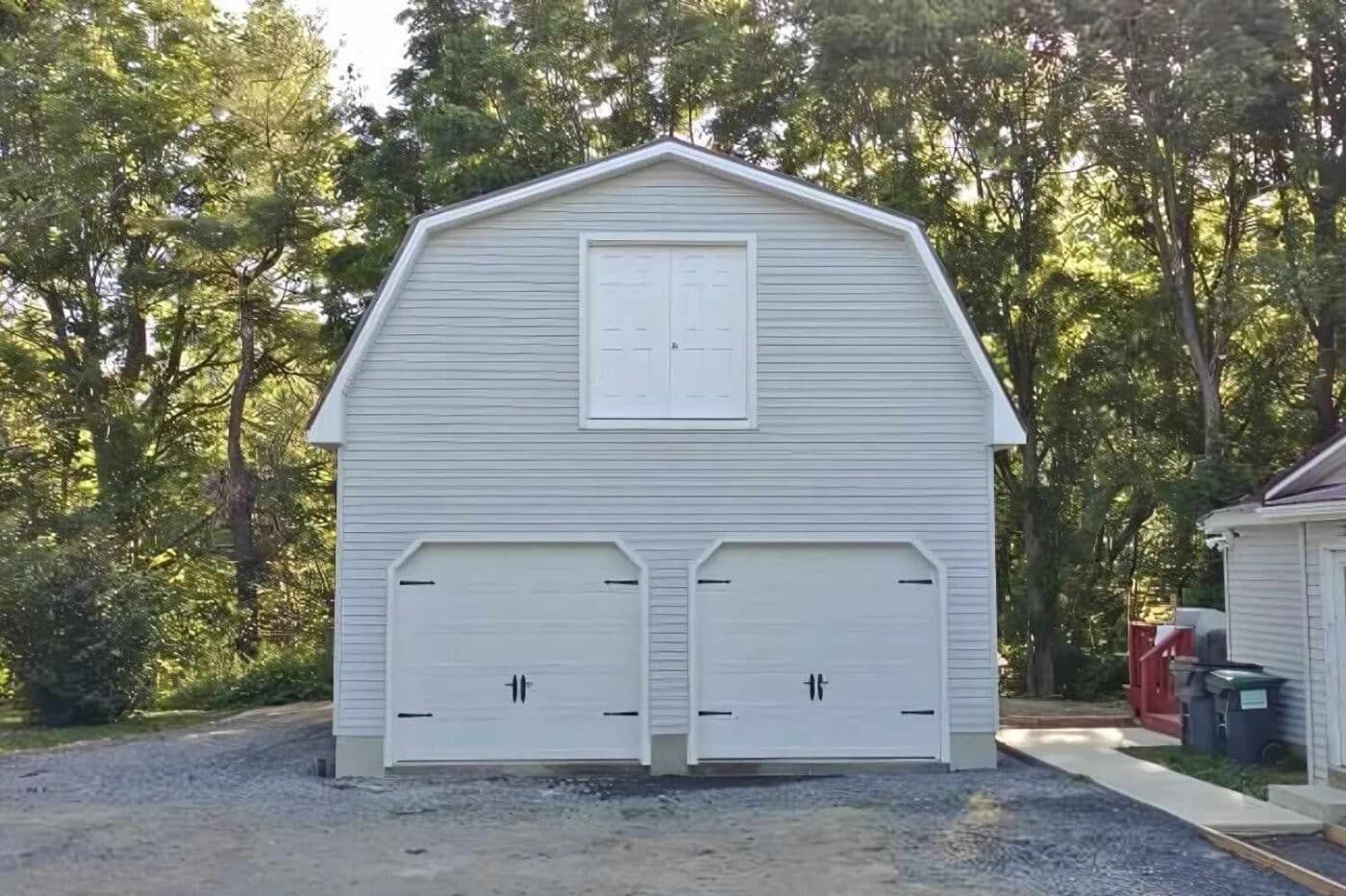 Front view of Gambrel garage with two garage doors, and a double entry door