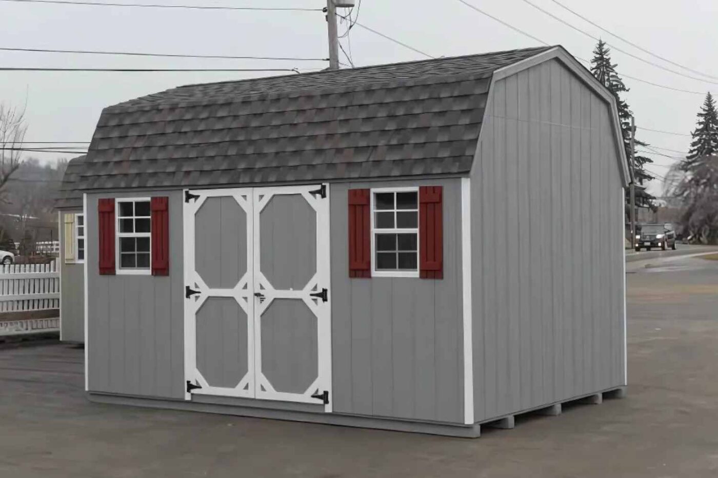 Gray high barn with white trim, red shutters, and double door