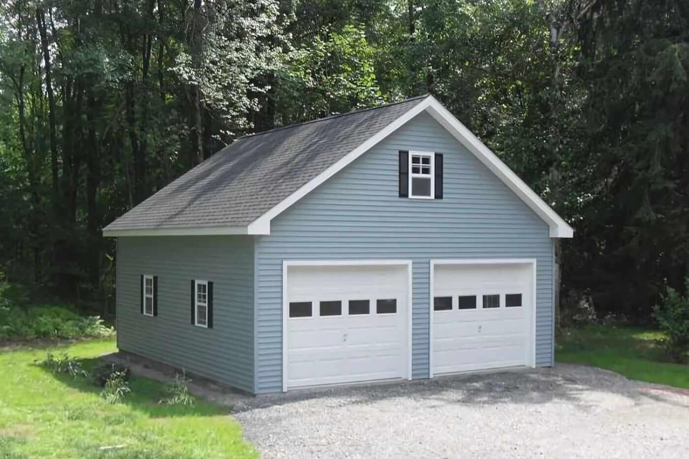 Blue garage with white garage doors and three windows with black trim