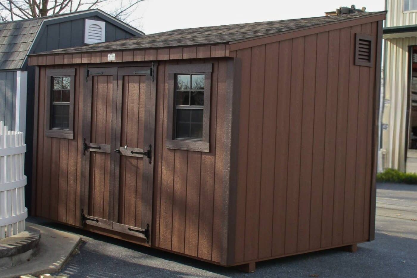 The Lean-To Shed 2 Lean-To shed with wood exterior with dark brown trim and brown siding