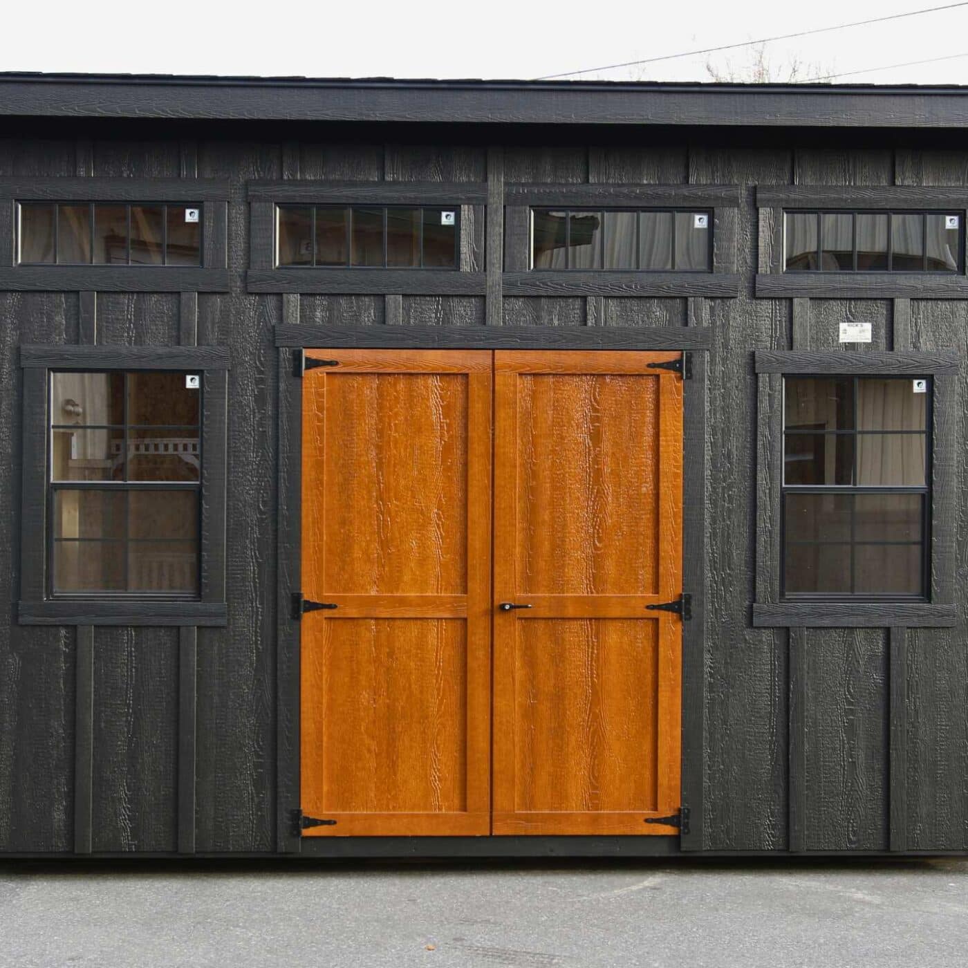 The Lean-To Shed 6 Lean-to shed viewed straight on with all windows visible and brown double doors