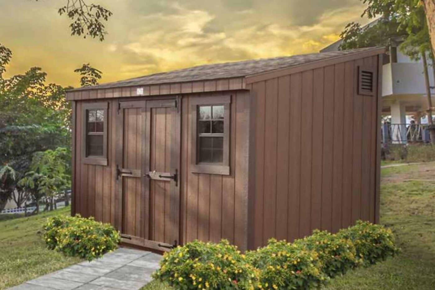 Brown lean-to shed in garden in front of sunset