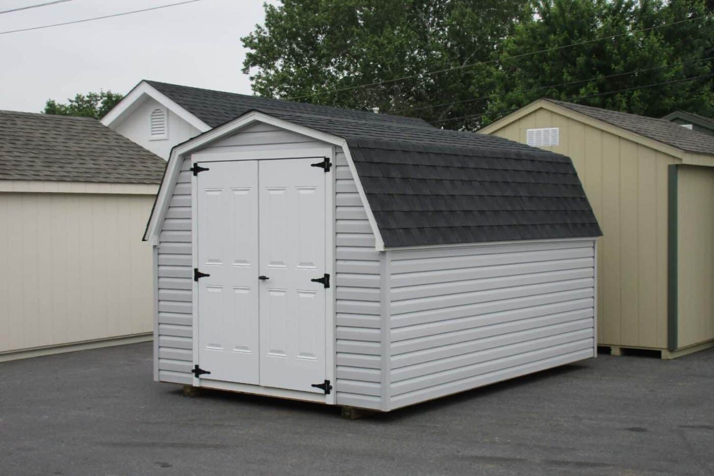 The Mini Barn Shed 3 White vinyl mini barn with double white doors in lot