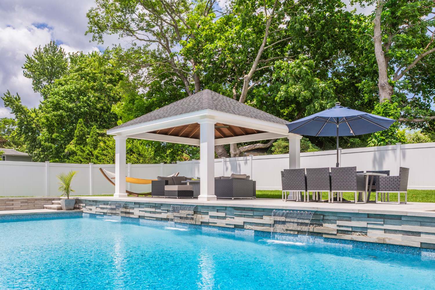 View of Pavilion across from pool with seating area and hammock 