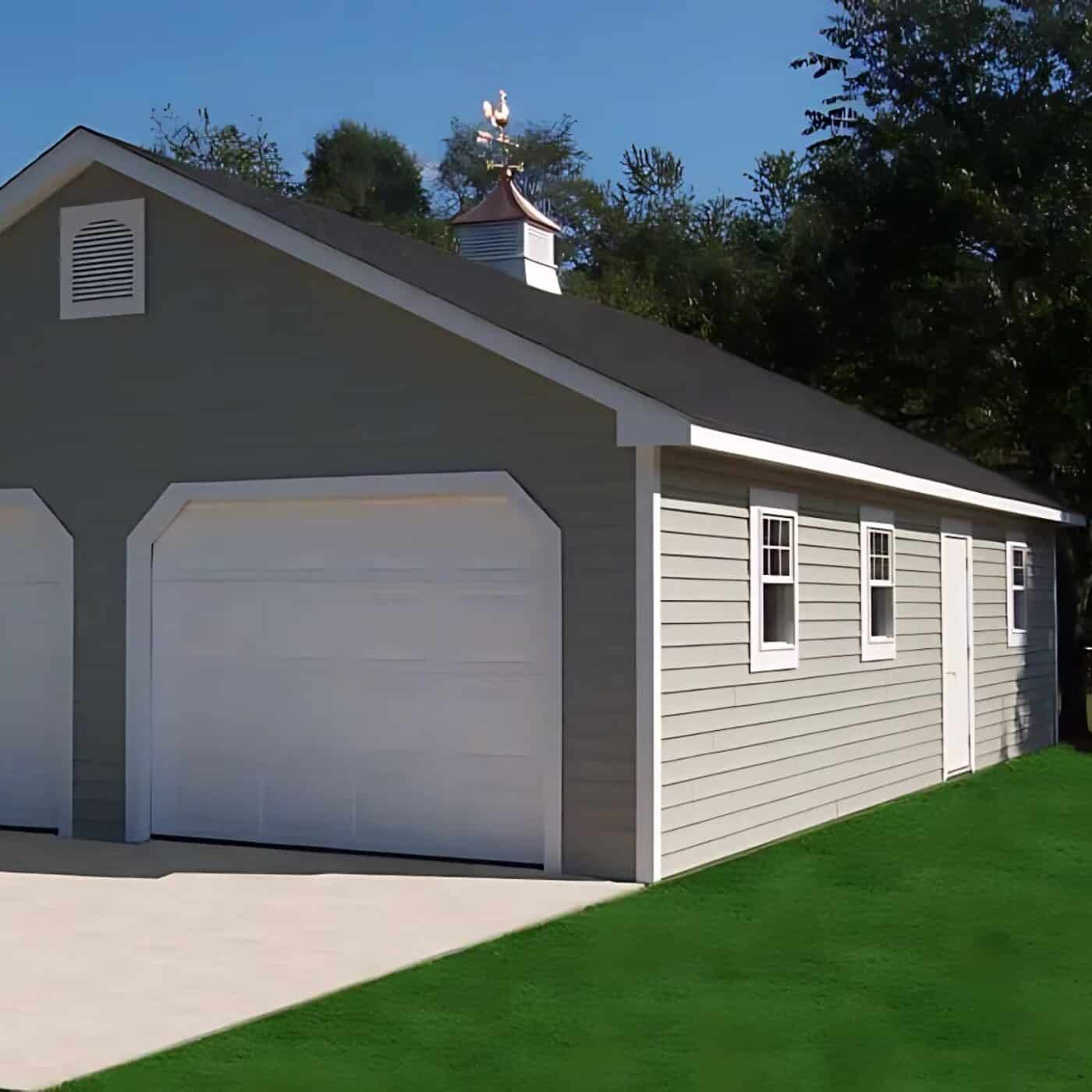 The A-Frame Truss Garage 4 Gray siding with white trim and white garage doors and cupola