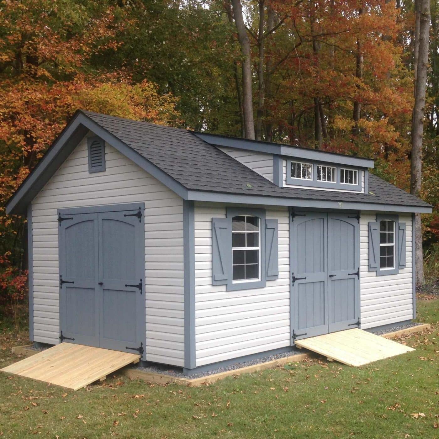 The Designer Workshop Shed 6 Designer Workshop Shed shown at angle to emphasize size with ramps, blue accents, and dormer