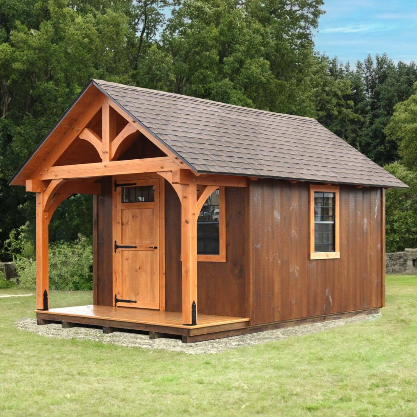 The Somerset Shed 4 Somerset Timber Frame Shed in grass before trees with porch and brown siding