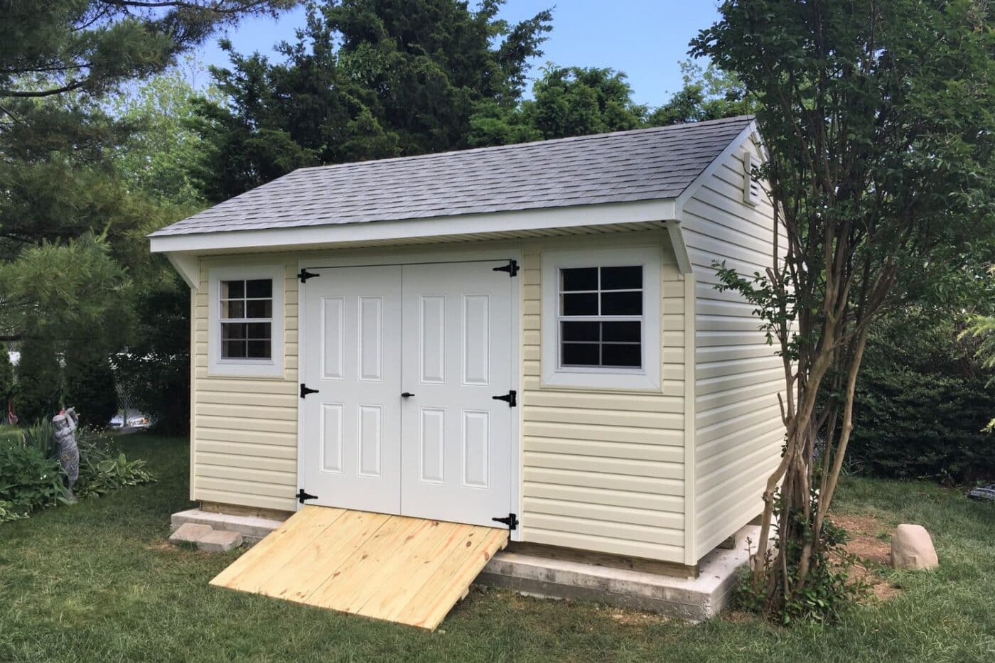 The Standard Carriage Shed 5 Vinyl Standard carriage shed with white doors, trim, and wooden ramp
