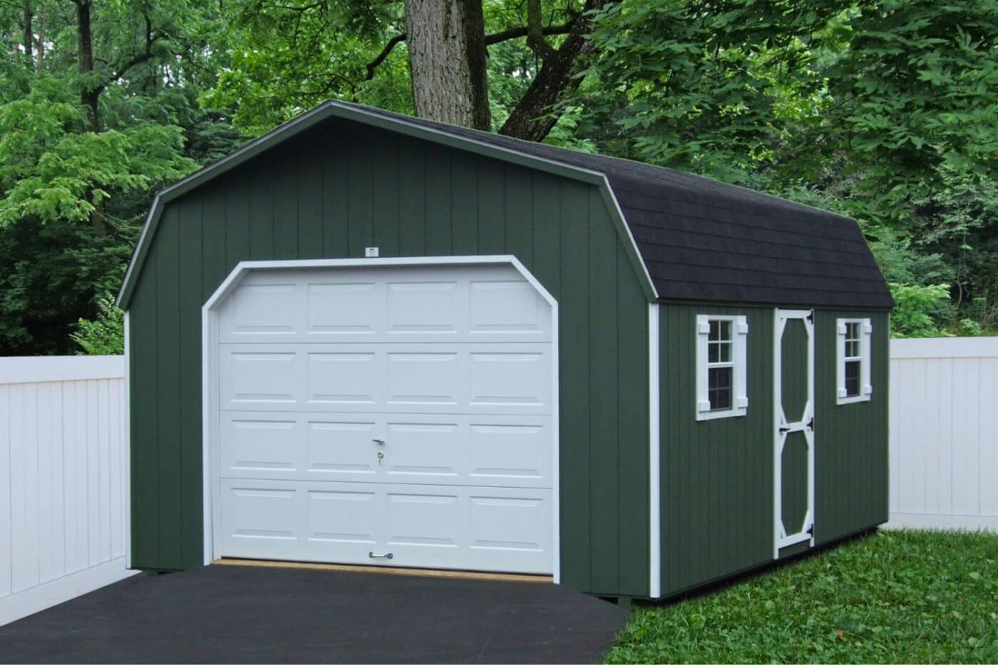 Green and white standard high barn garage shed with white trim and black asphalt shingle roof