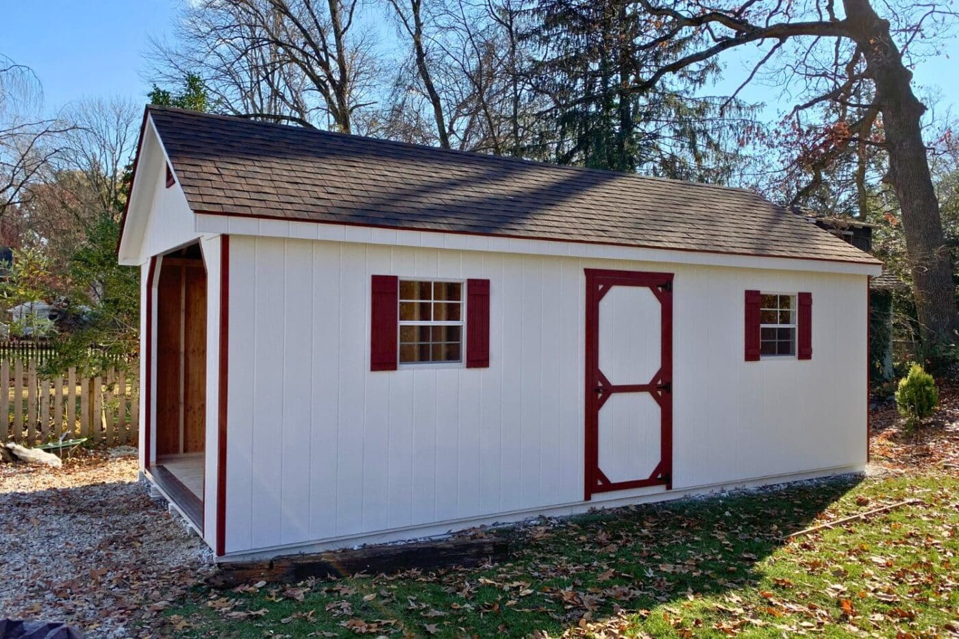 White and red standard workshop garage in yard with open garage door