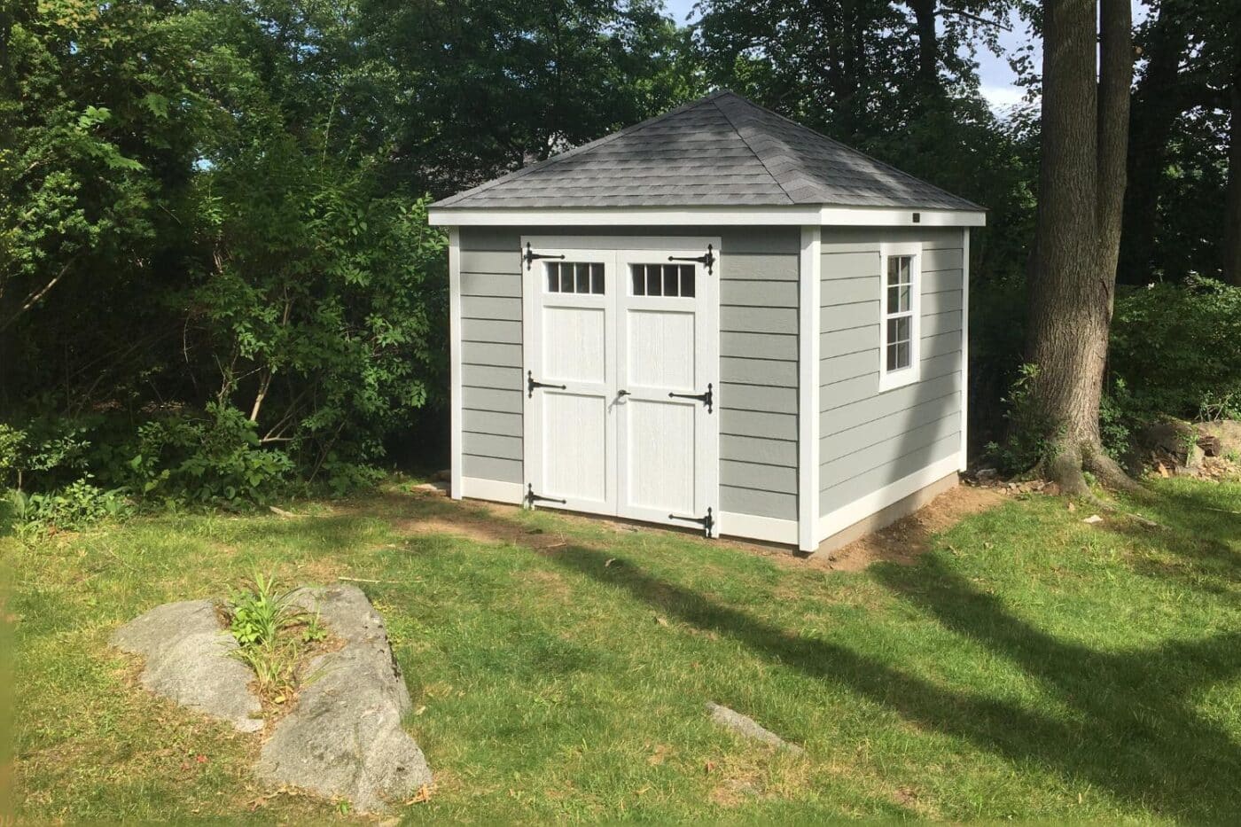 The Cabana Shed 2 Gray and white cabana shed in sunlight with double door