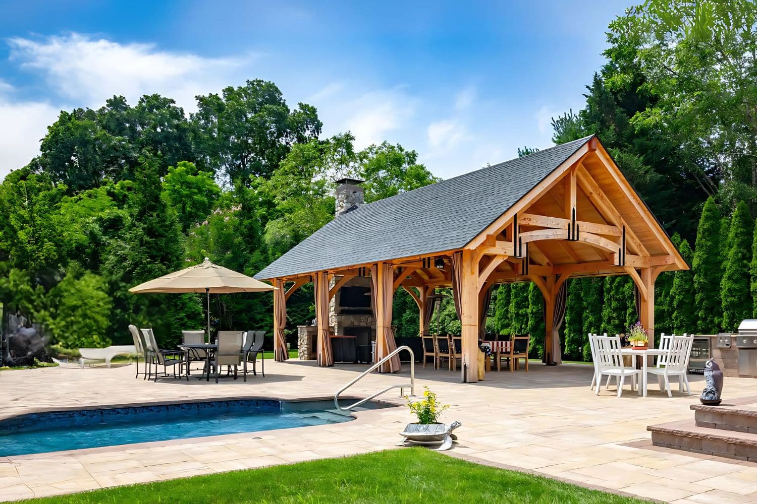 The Grand Teton Timber Frame Pavilion besides pool and seating areas