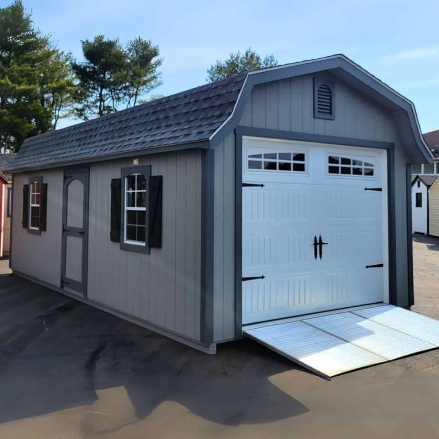 The Designer High Barn Garage 4 Gray and white designer high barn garage shed with dark trim and metal ramp
