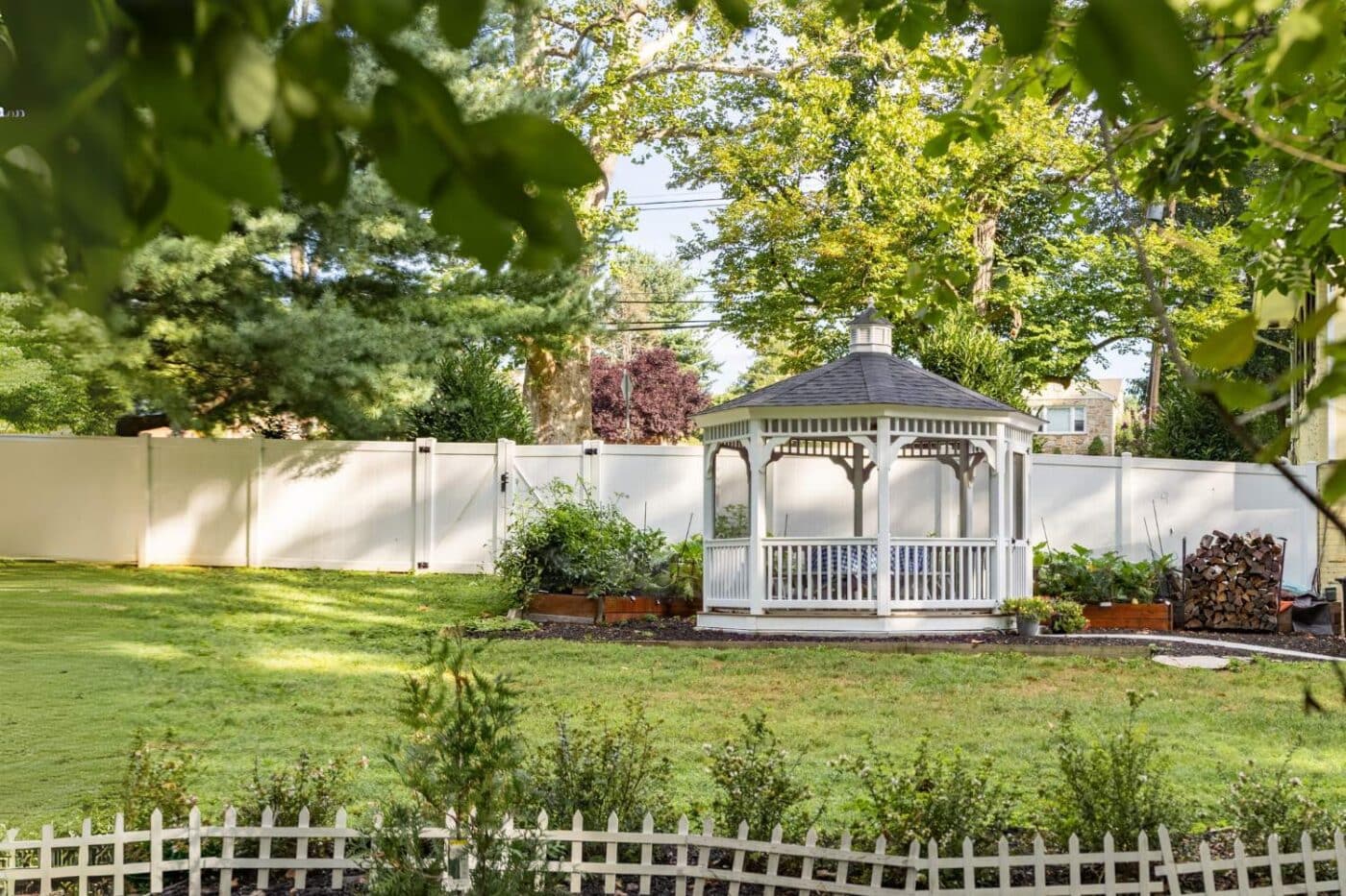 The Vinyl Octagon Gazebo in garden with white vinyl