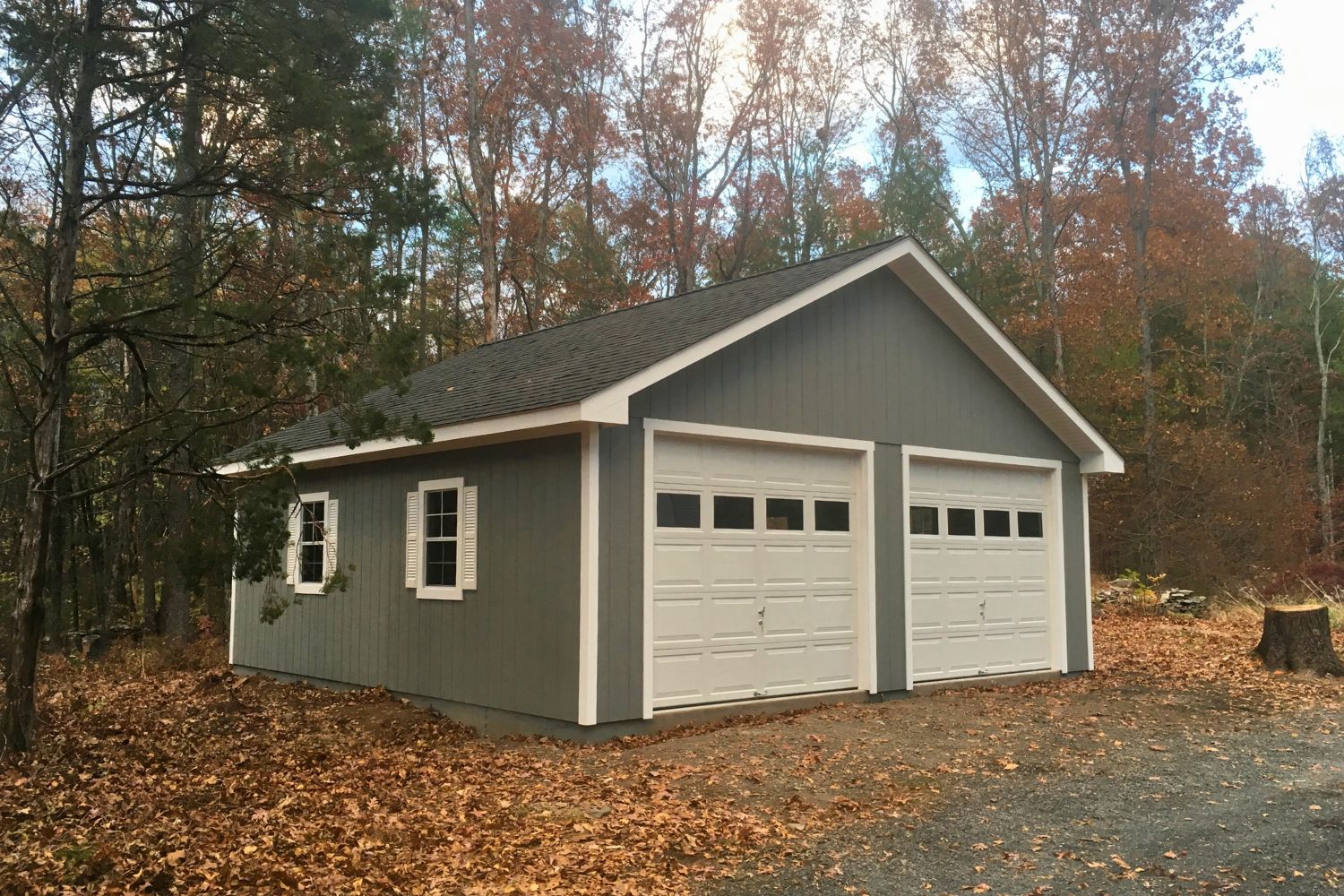 A-Frame Truss garage in lot with fall leaves and trees surrounding