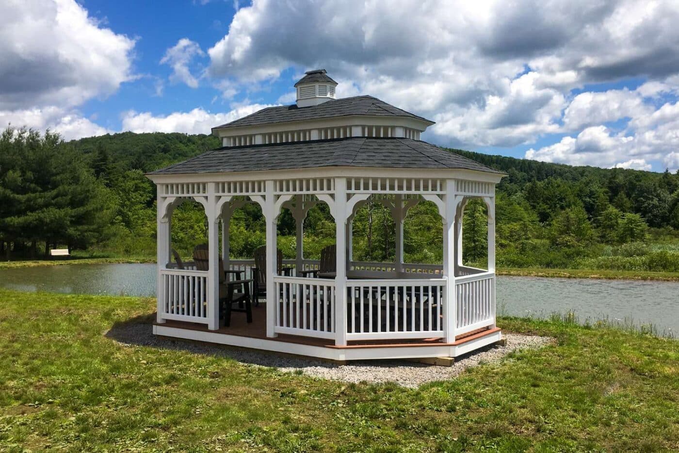 Vinyl Oval Gazebo besides lake on gravel foundation