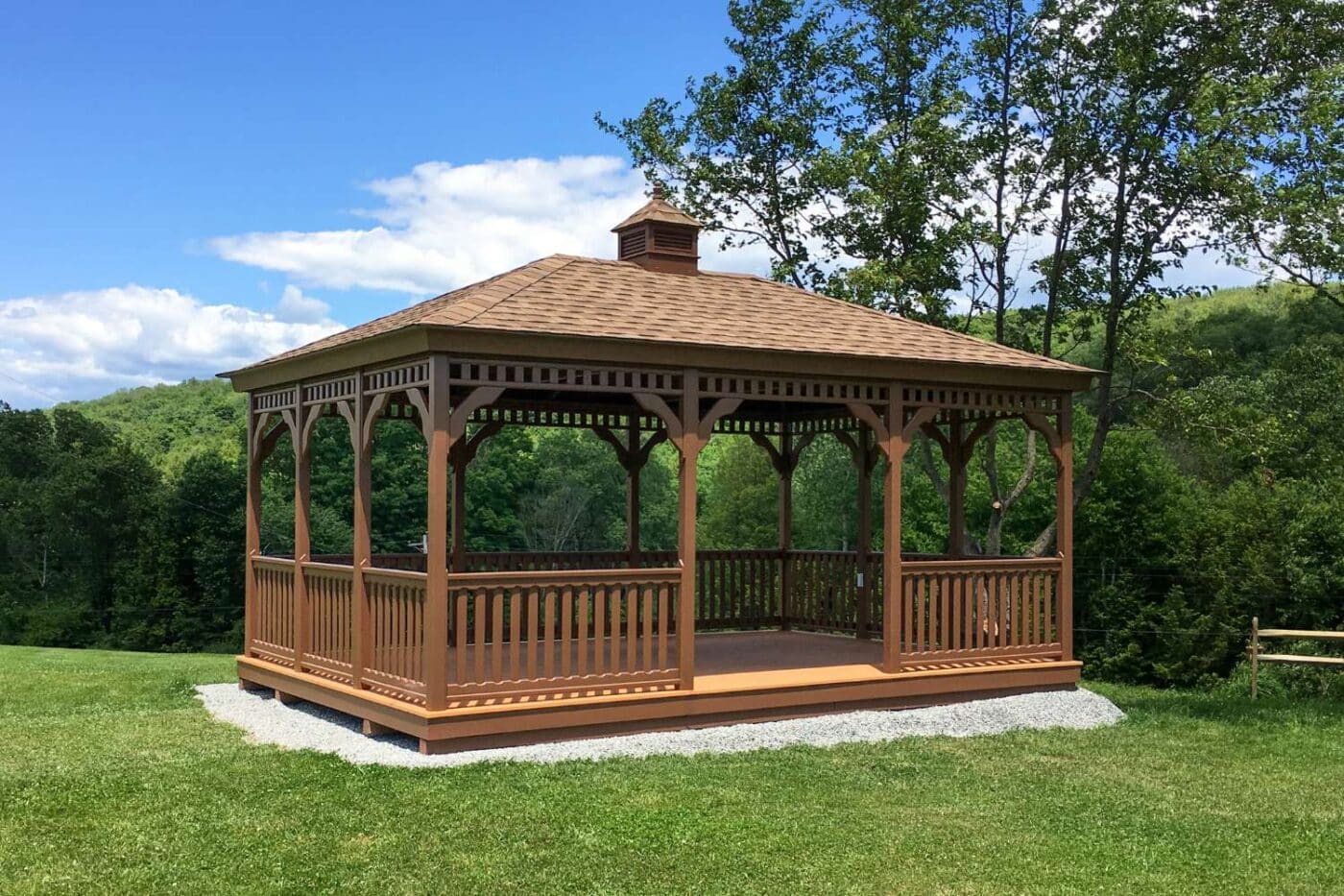 Wood Rectangle Gazebo with railing and cupola on top of gravel foundation